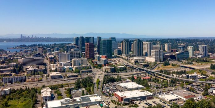 Downtown Bellevue viewed from the east with I-405 chasm setting off Wilburton. Seattle skyline and Lake Washington in the background. (