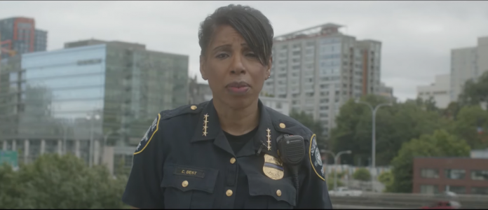 Chief Best with a Downtown Seattle buildings and street behind her. Video is here: https://www.seattle.gov/police/together
