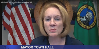 Mayor Durkan flanked by the American flag and Washington state flag.