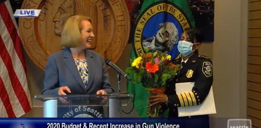 Mayor Jenny Durkan gave soon-to-retire Police Chief Carmen Best some flowers to express her gratitude during a press conference about blocking police budget cuts in the Norm Rice room at City Hall. (Seattle Channel)
