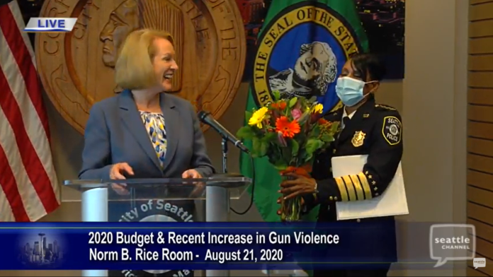 Mayor Jenny Durkan gave soon-to-retire Police Chief Carmen Best some flowers to express her gratitude during a press conference about blocking police budget cuts in the Norm Rice room at City Hall. (Seattle Channel)