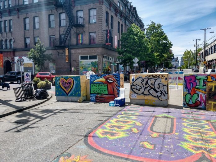 Pine Street in CHOP The B from the Black Lives Matter street mural next to barricades with Oddfellows building in the background.