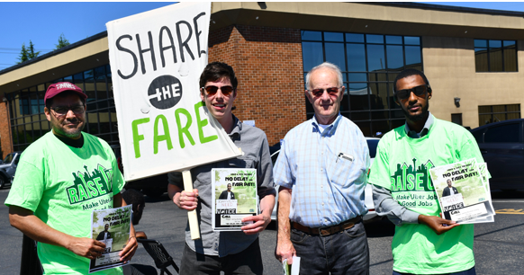 Four drivers union members pose with literature, "Raise Up" shirts, and a "Share the Fare" signs.