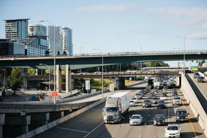 I-405 northbound car traffic with bridges and skyscrapers in the background.