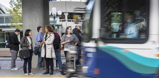 Seven passengers wait to board a Sound Transit bus. (Photo courtesy of Sound Transit)