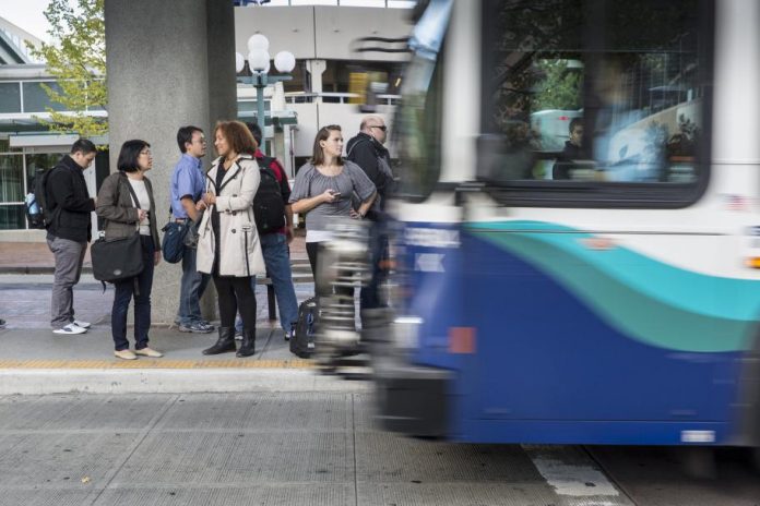 Seven passengers wait to board a Sound Transit bus. (Photo courtesy of Sound Transit)