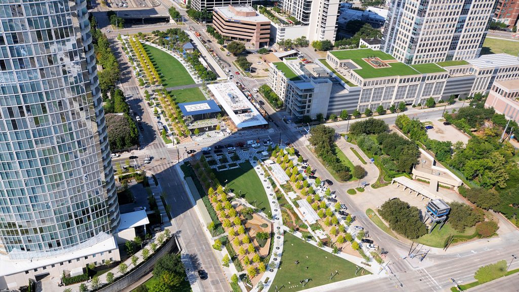 A grassy Klyde Warren Park is flanked by large skyscrapers.