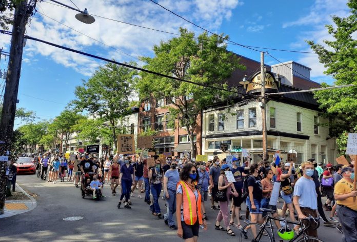 Protesters marching on Ballard Avenue with signs