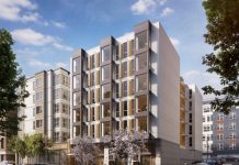 Seattle Social Housing Developer Strives for High Sustainability and Affordability Standards A white six story building with jutting windows.