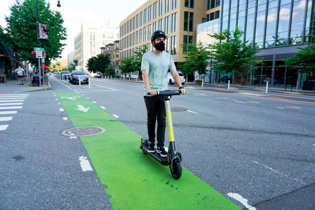 Man riding a LINK scooter in a green bike lane in South Lake Union