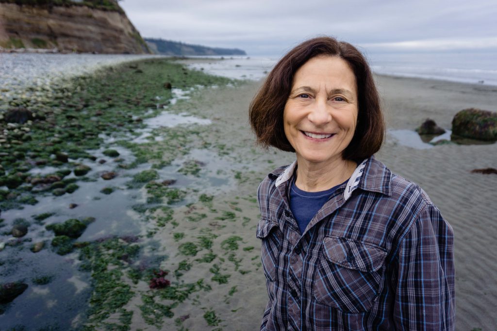 Angie Homola stands next to Puget Sound, a ubiquitous presence in the 10th, for this campaign photo.