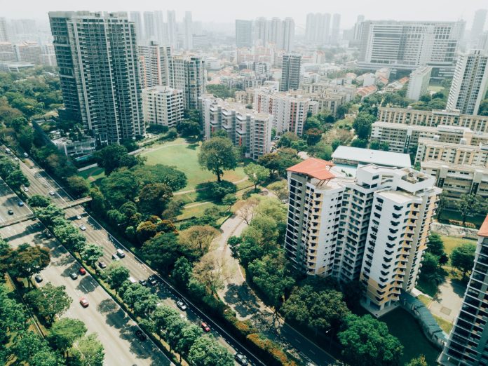 Residential towers and tree-lined streets with haze on the horizon.