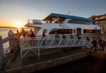 Metro Pours Some Cold Water on a Kenmore-Seattle Water Taxi Ferry at the dock with the sunset in the background.