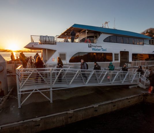 Metro Pours Some Cold Water on a Kenmore-Seattle Water Taxi Ferry at the dock with the sunset in the background.