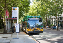 2021 Fall Transit Service Changes Are Coming to Puget Sound Agencies A photo of a King County Metro bus pulling into a bus station on a tree-lined street.