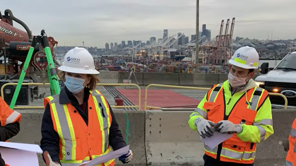 Mayor Durkan in an orange vest and SDOT hard hat at a West Seattle Bridge presser.