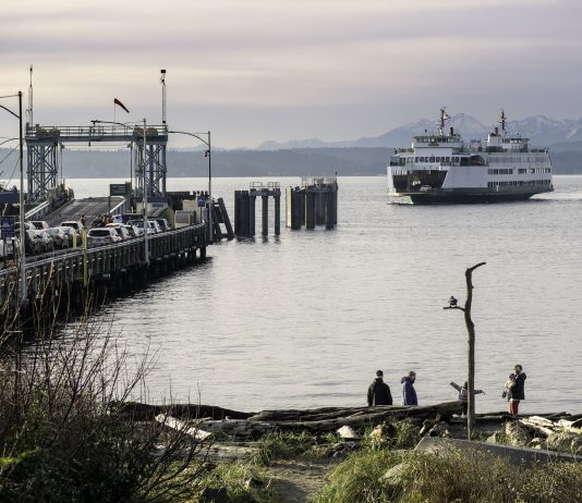 Policy Lab: We Want Bread, and Paid Vacation Too! Folks walk the beach as the Washington State ferry comes in. Cars wait on the dock.