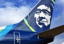 SEA Airport Passenger Numbers Tumble 61% in 2020 The Alaska Airline logo on the fins with the blue skies and clouds in the background.