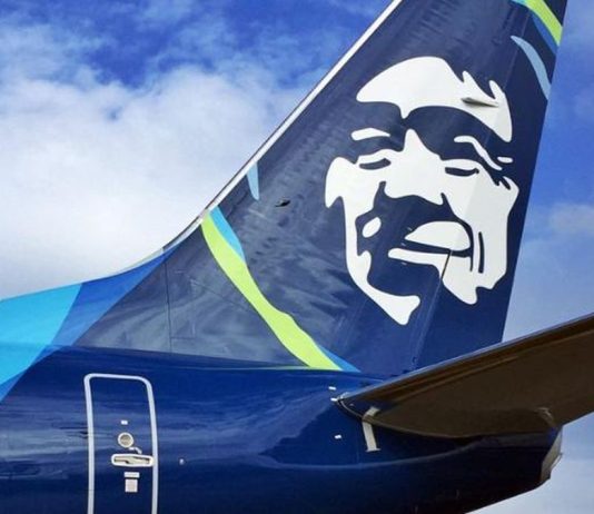 SEA Airport Passenger Numbers Tumble 61% in 2020 The Alaska Airline logo on the fins with the blue skies and clouds in the background.