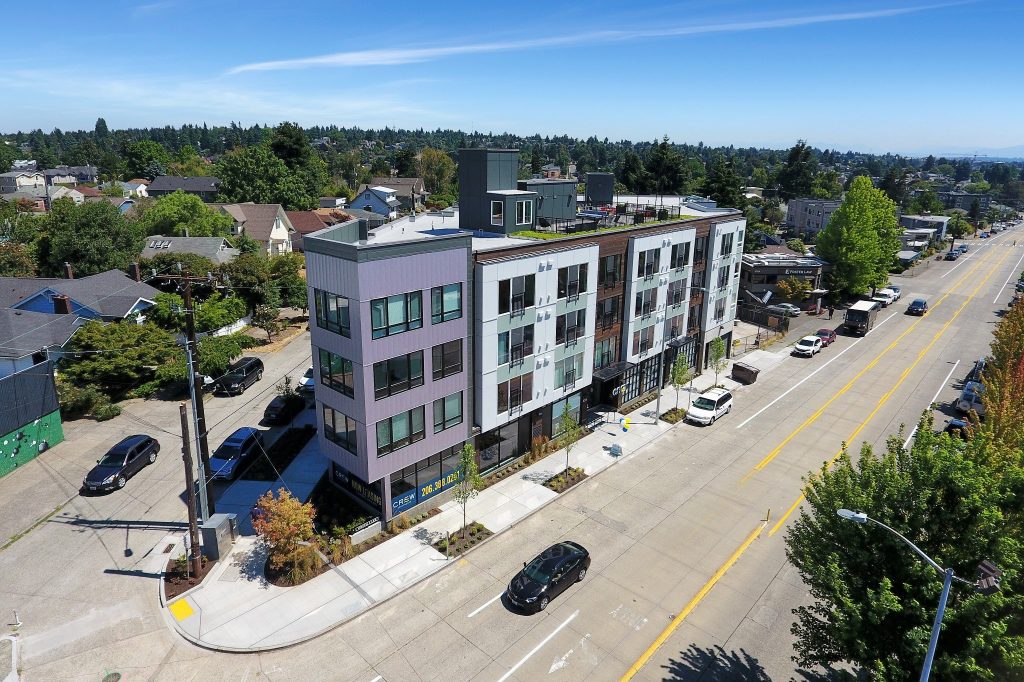 A four story apartment building elegantly gracing a triangular lot.