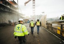 Seattle Subway-Backed HB 1304 Gets First Hearing February 9th Three construction workers in Sound Transit vests walk a construction site with crane overhead.