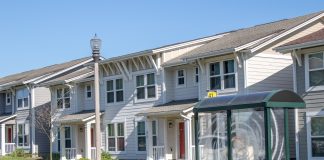 A rowhouse with a transit shelter.