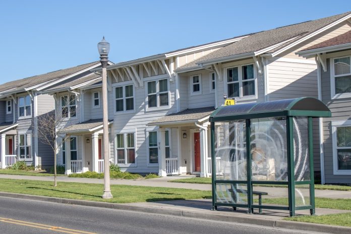 A rowhouse with a transit shelter.