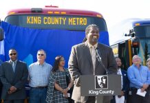 Terry White Has Deep Roots and Big Plans as Metro General Manager Terry White at a podium in front of a Metro bus flanked by Metro coworkers at a 2018 event.