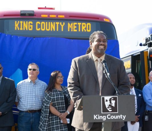 Terry White Has Deep Roots and Big Plans as Metro General Manager Terry White at a podium in front of a Metro bus flanked by Metro coworkers at a 2018 event.