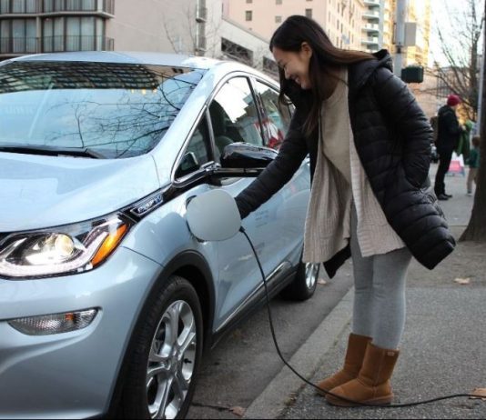 Macri Bill Proposes Banning New Fossil Fuel Cars in 2030 A women charges an electric sedan.