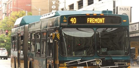 A green and yellow Route 40 with Fremont displayed on its screen with downtown towers in background.