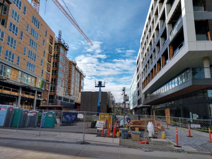 Seven-story midrise apartments along a pedestrian plaza.