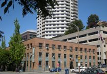 Unions Head South but Negotiate Plan to Preserve the Labor Temple Building The three story brick labor temple with teal accents. A Belltown skyscraper is in the background.
