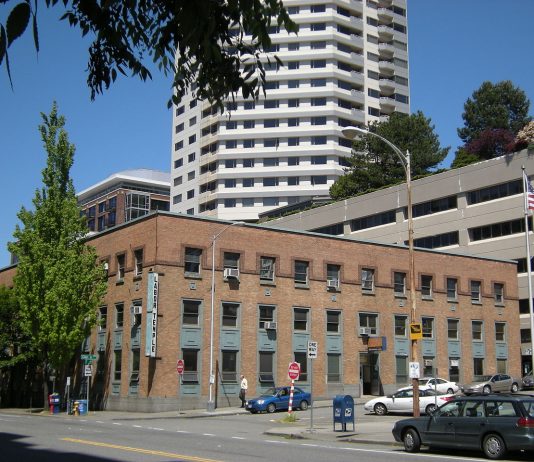 Unions Head South but Negotiate Plan to Preserve the Labor Temple Building The three story brick labor temple with teal accents. A Belltown skyscraper is in the background.