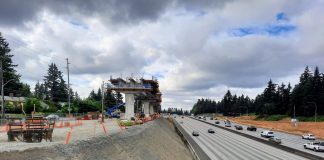 A light rail guideway rises on the edge of the I-5 freeway trench at the 130th Street overpass in Seattle.