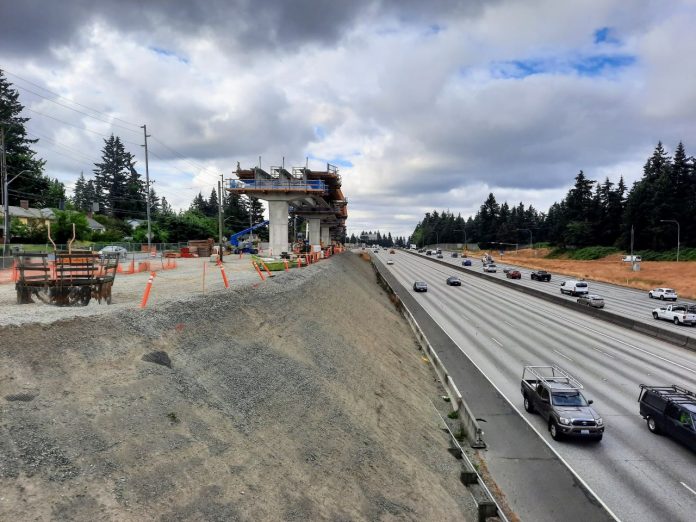 A light rail guideway rises on the edge of the I-5 freeway trench at the 130th Street overpass in Seattle.