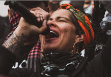 Nikkita Oliver’s March to City Hall Continues with City Council Bid Nikkita Oliver projecting into a microphone.