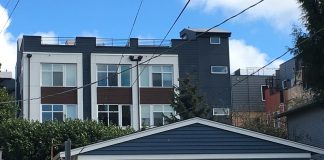 Photo of a single-story duplex in Wallingford, with three-story townhomes behind it.