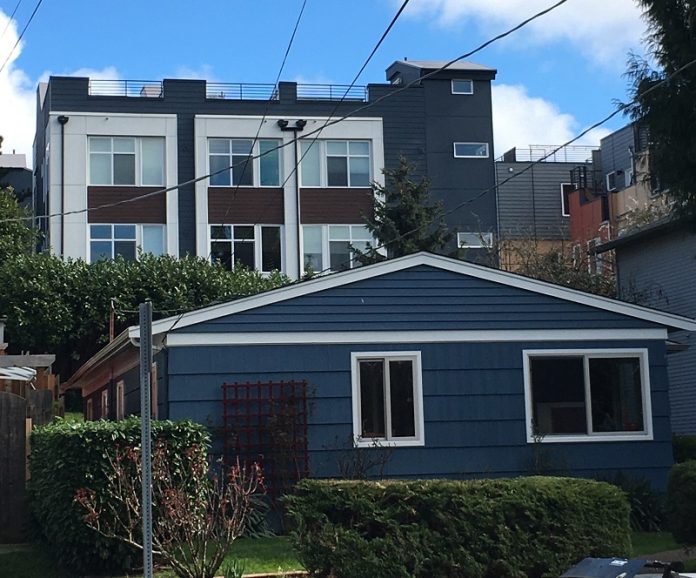 DuplexWithTownhomesBehind Photo of a single-story duplex in Wallingford, with three-story townhomes behind it.