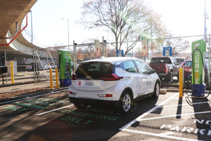 A white SUV next to a charging port.