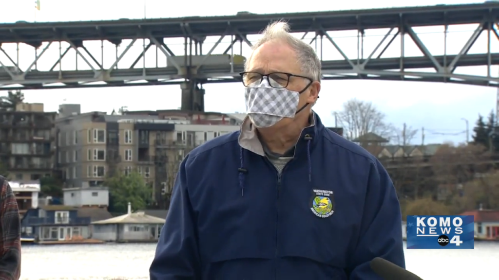 Governor Inslee with a mask speaking in front of I-5 Ship Canal Bridge.