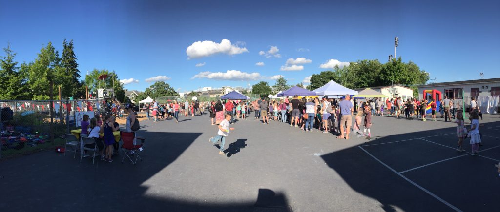 kids scampering it a parking lot at a school carnival.