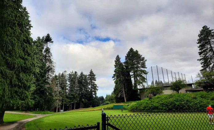Jackson-Park-Golf-Course-with-fence A golf course and driving range with a fence in the foreground.