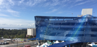 A four-story parking structure with a blue decorative screen.