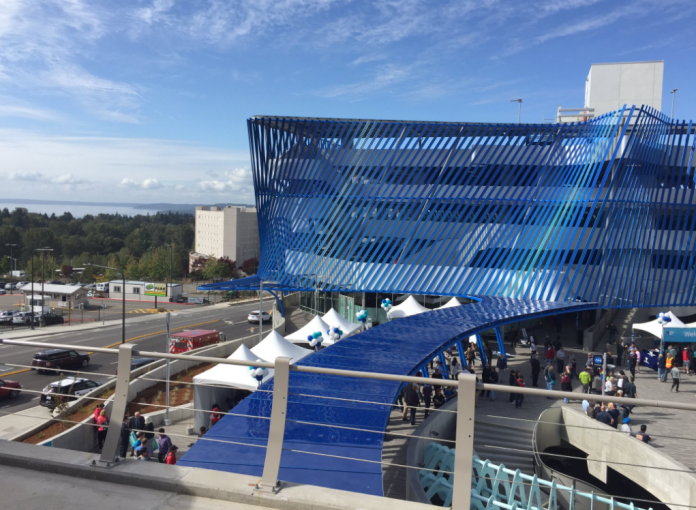 A four-story parking structure with a blue decorative screen.