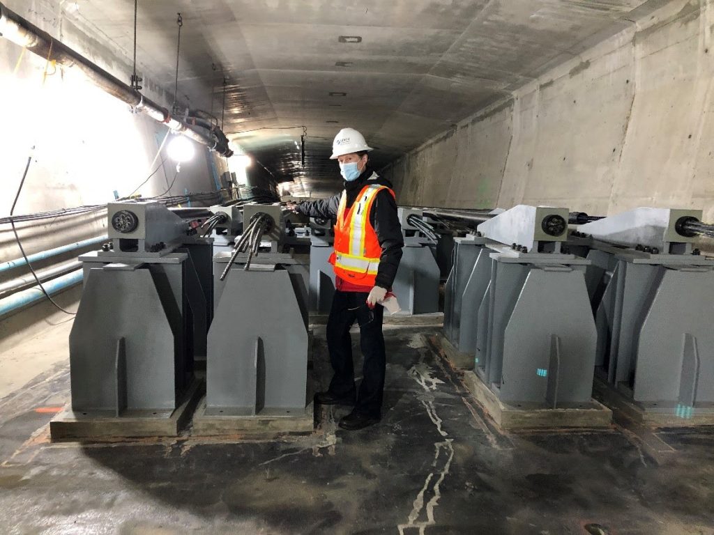 Alex Pedersen standing inside the West Seattle Bridge next to cable ends