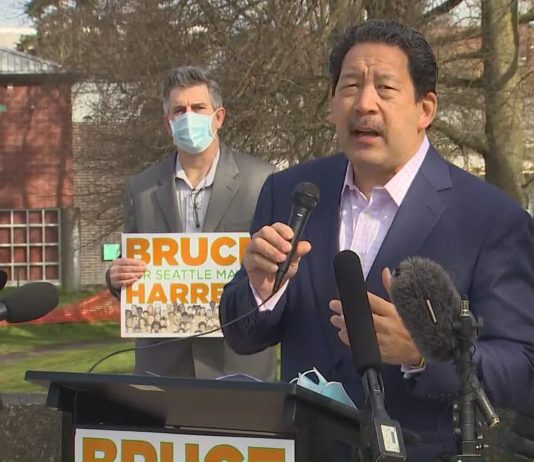 Bruce Harrell Would Follow the Data as Mayor, but Where Will It Lead Him? Bruce Harrell in a suitcoast with a microphone in hand at his candidacy announcement press conference.