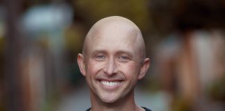 Image description: Ron is a bald White man wearing a black shirt and a smile.
