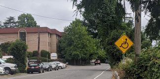 A yellow sign with a wheelchair on it indicates the people rolling are to use the gutter after the sidewalk ends. They did paint a stripe along the gutter at least.