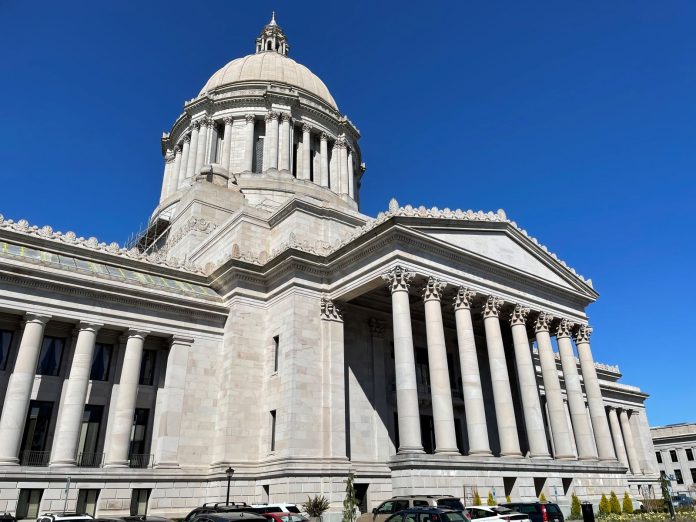 The Capitol building in Olympia is marble colored and include pillars and a dome in the classic style.